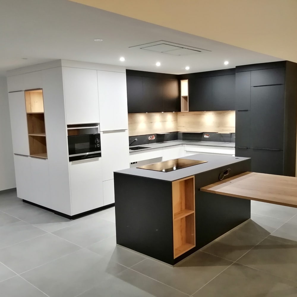 Cuisine sur mesure blanche et noire avec îlot central et table en chêne