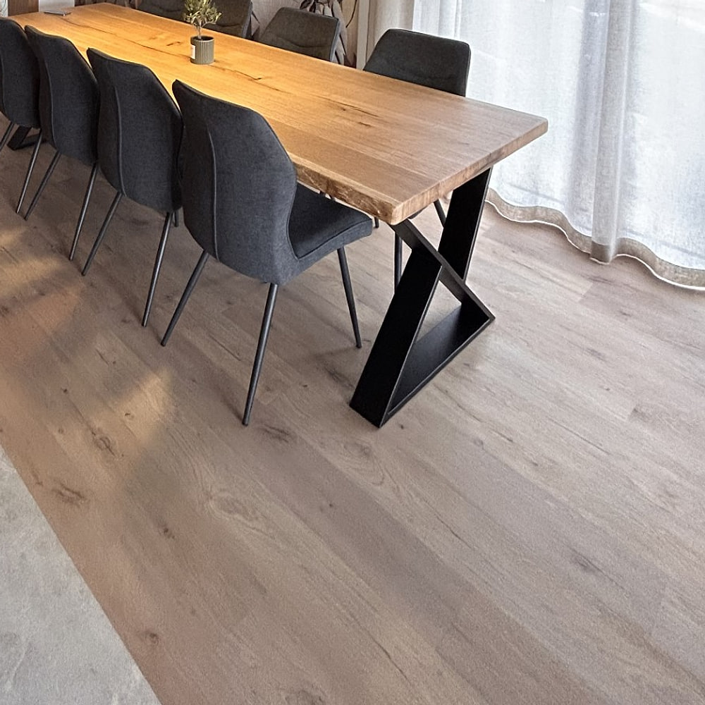 Parquet en chêne clair posé dans une salle à manger, sous une table en bois massif