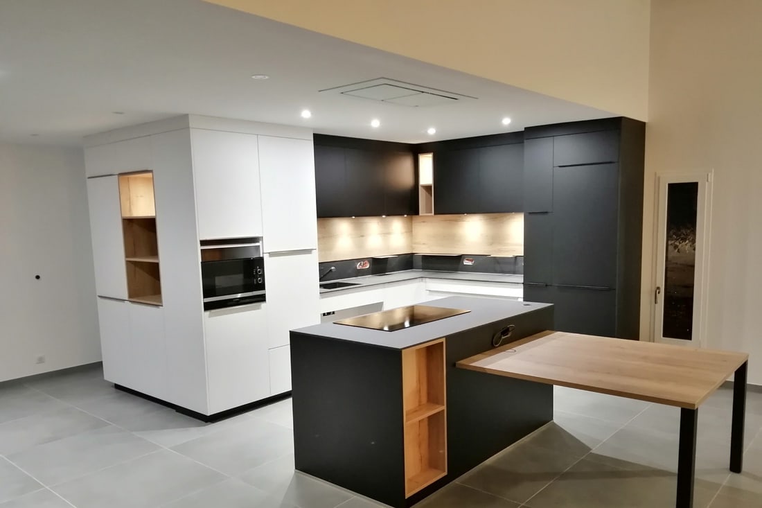 Cuisine sur mesure blanche et noire avec îlot central et table en chêne
