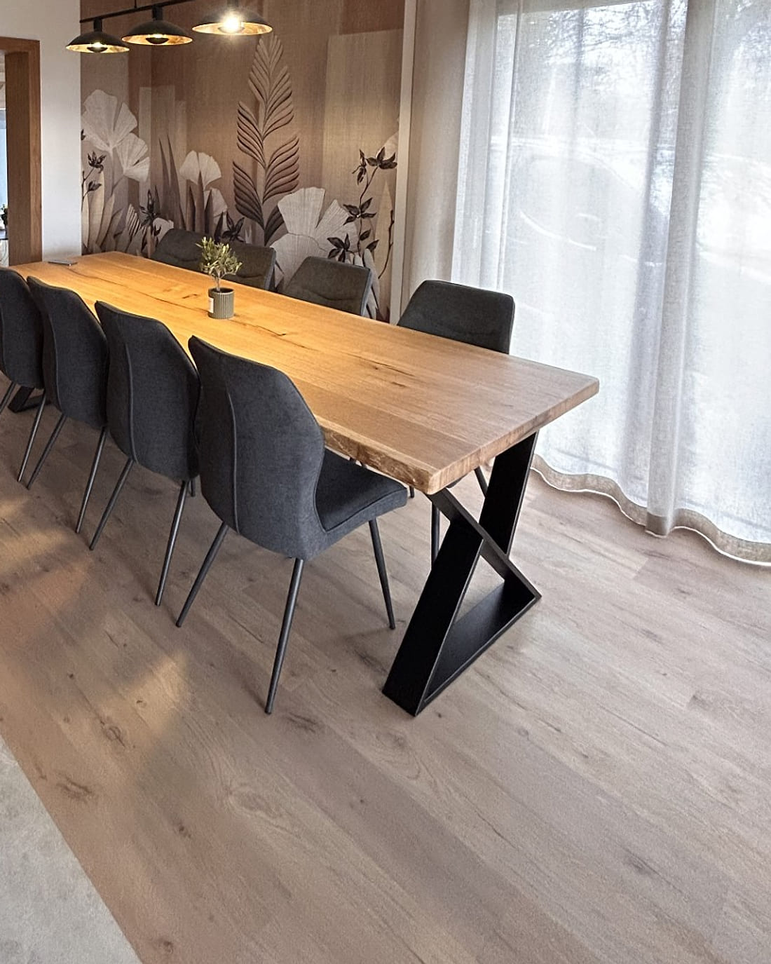 Parquet en chêne clair posé dans une salle à manger, sous une table en bois massif