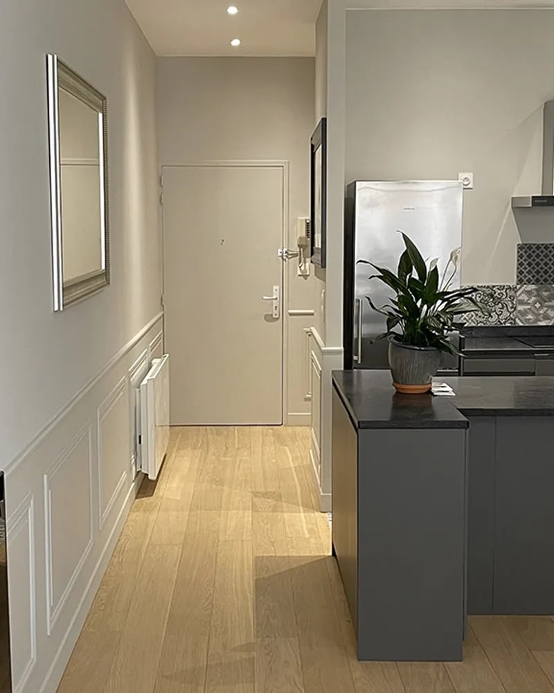 Entrée et cuisine d'appartement rénové, parquet chêne et soubassement mouluré