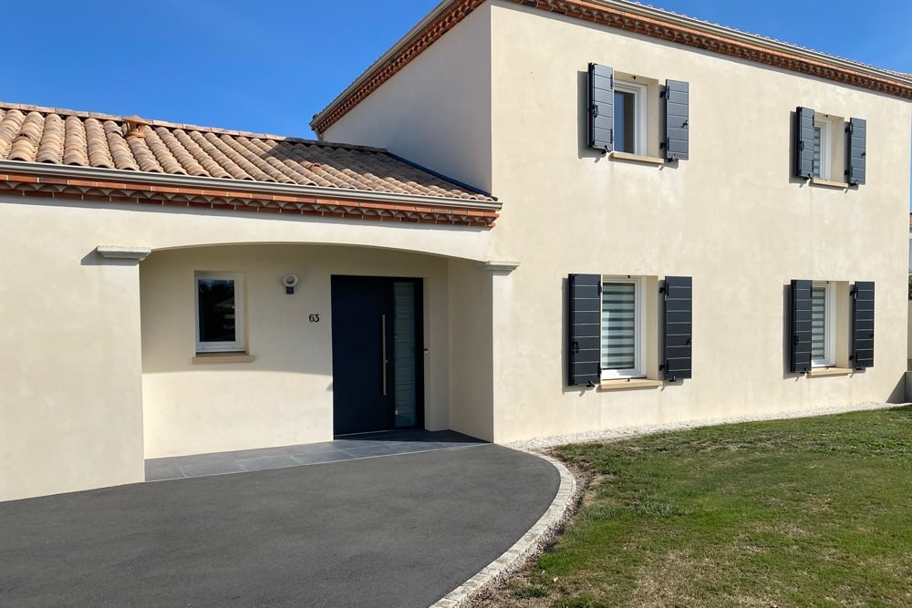 Façade de maison équipée de volets battants en aluminium gris anthracite